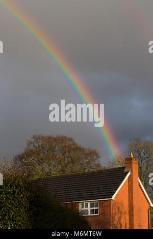 Un arc-en-ciel au-dessus d'une maison moderne en UK Banque D'Images