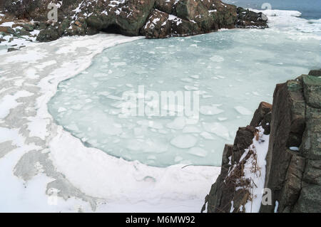 Beaucoup de blocs de glace flottent dans l'eau de mer dans une baie pittoresque. Le printemps est arrivé Banque D'Images