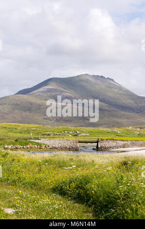 Les collines de South Uist à partir de l'embouchure de la rivière Howmore avec le pont sur la rivière au milieu de terrain et les dunes de sable et de "machair" en premier plan Banque D'Images