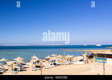 Parasols et chaises longues sur une plage privée dans la station balnéaire d'Hurghada. Mer Rouge, Egypte Banque D'Images