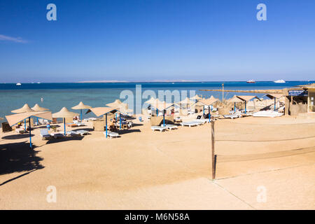 Parasols et chaises longues sur une plage privée dans la station balnéaire d'Hurghada. Mer Rouge, Egypte Banque D'Images