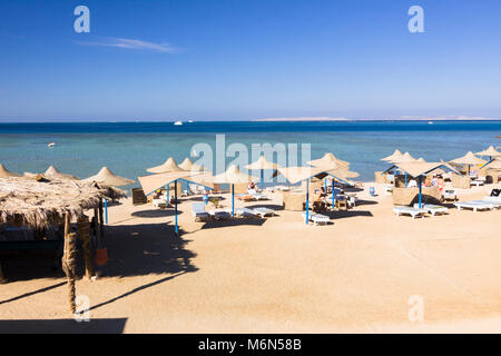 Parasols et chaises longues sur une plage privée dans la station balnéaire d'Hurghada. Mer Rouge, Egypte Banque D'Images