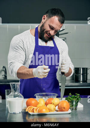 Barbu forte chef prépare des jus et salade Banque D'Images