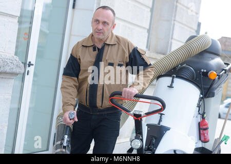 Travail heureux homme debout près de poubelle sur street Banque D'Images