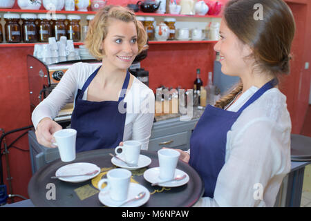 Deux femmes posant dans coffee house en uniforme Banque D'Images