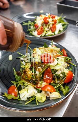 Chef pouring sauce à salade, cuisson, concept de restaurant Banque D'Images