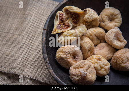 Les figues sèches dans un bol en bois rustique, des fruits secs, fermer l'alimentation à la vie encore Banque D'Images