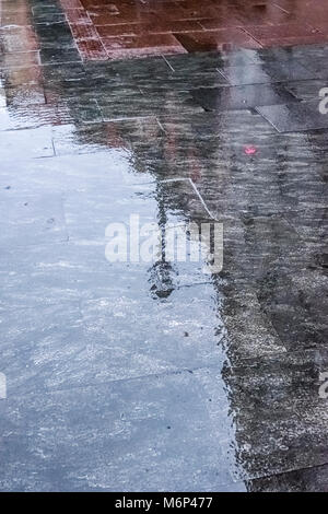 Le reflet d'un lampadaire sur une chaussée mouillée à Madrid pendant un jour de pluie. Banque D'Images