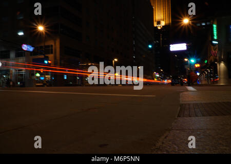 Light trails de nuit à travers le centre-ville de Minneapolis au Minnesota. Frein de stationnement et les phares streak brille vers le bas rue bondée Banque D'Images