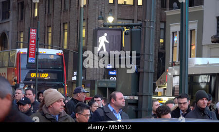 New York City - Circa 2017 : continuer à pied symbole sur poteau d'éclairage de rue à midtown Manhattan à l'heure de pointe. Les banlieusards attendre la circulation automobile Banque D'Images