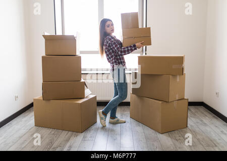 Une femme transporte un carton rempli Banque D'Images