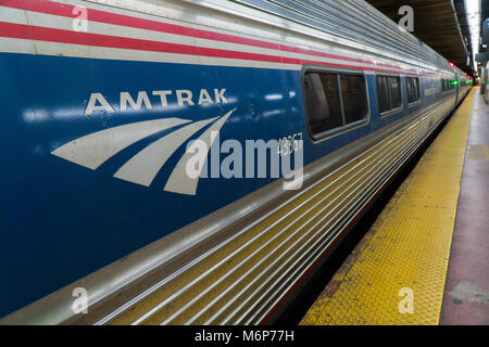 New York City, vers 2017 : Amtrak Train à Penn Station terminal railroad Manhattan de la plate-forme. Rouge Blanc et bleu logo. Rail interurbains d'affaires com Banque D'Images