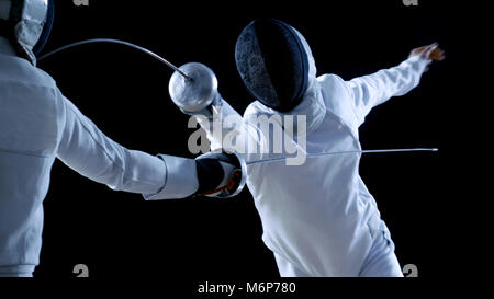 Deux tireurs professionnels montrent de l'Épée de Maître dans leur lutte d'aluminium. Ils attaquent, défendre, Leap et de poussée et sur une jambe. Banque D'Images