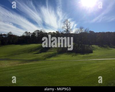 Beatufiul à la vue sur l'allée jusqu'à une colline d'un terrain de golf en fin d'après-midi près de coucher du soleil. L'ensemble de la strie nuages ciel bleu Banque D'Images