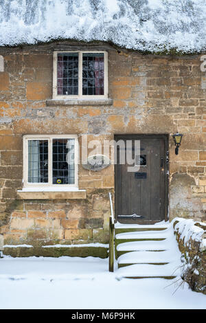 Stanton pierre chaume cottage dans la neige d'hiver. Stanton, Cotswolds, Worcestershire, Angleterre Banque D'Images