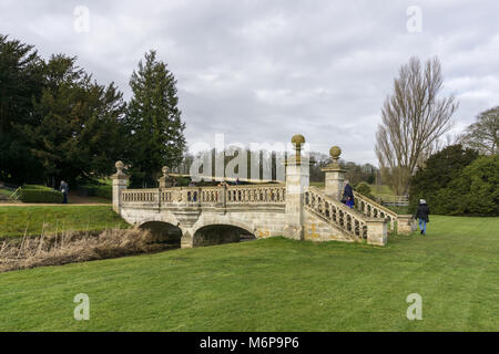 Easton walled gardens en hiver, avec les visiteurs d'admirer le pont d'ornement ; près de Grantham, Lincolnshire, Royaume-Uni Banque D'Images