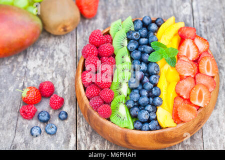 Fresh fruits colorés et de baies dans bol en bois sur table rustique Banque D'Images