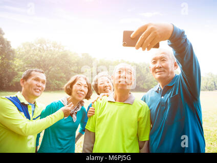 Groupe d'amis prenant Selfies Banque D'Images