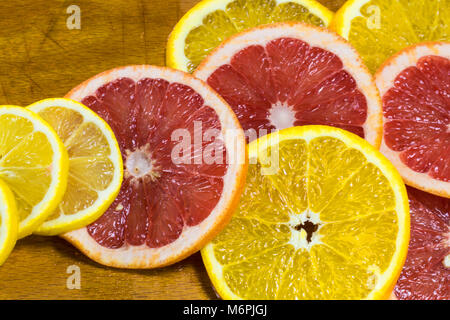 Anneaux d'Orange et de pamplemousse juteux sur une planche en bois Banque D'Images