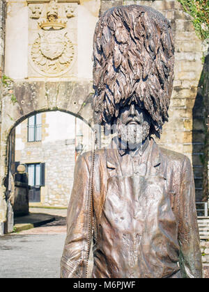 HONDARRIBIA, ESPAGNE-15 février 2018 : statue en bronze d'un soldat barbu Hondarriban Hatxeroa' (') à Bearskin hat à l'aide d'une scie Banque D'Images