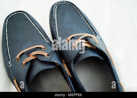 La marine en cuir chaussures avec lacets marron sur le plancher blanc Banque D'Images