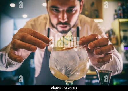 Barman est expert avec le concombre cocktail de décoration Banque D'Images