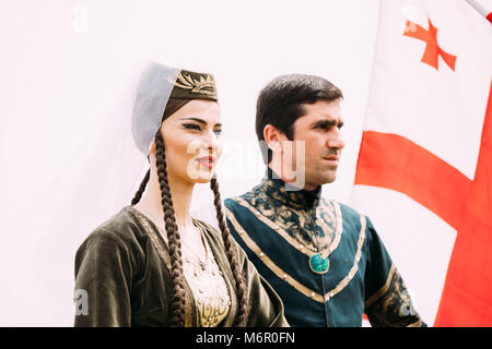 Batumi, Géorgie, l'Adjarie - Mai 26, 2016 : jeune couple de l'homme et de la femme dans les vêtements nationaux géorgiens sur le drapeau historique en célébration de l'h Banque D'Images