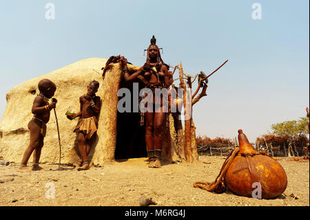 Femme Himba avec ses enfants devant sa hutte près d'Epupa Falls, en Namibie Banque D'Images