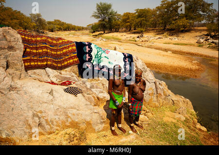 Habitants du nord de la Namibie le lavage des vêtements à une petite rivière à proximité Ehomba dans le Kaokoland, près de la frontière de l'Angola, Namibie Banque D'Images