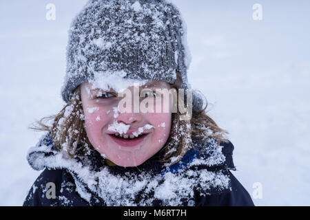 Un jeune garçon de la luge et de profiter de la neige. Banque D'Images