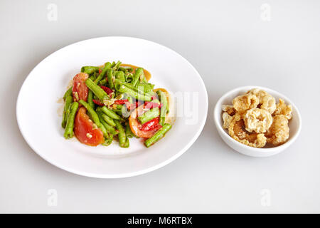 Cuisine traditionnelle thaïlandaise, de la nourriture locale, concombre Salade épicée, Croustillant de peau de porc sur fond blanc - Vue de dessus Banque D'Images