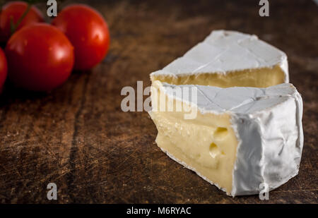 Libre de fromage brie et tomates cerises sur planche à découper en bois Banque D'Images