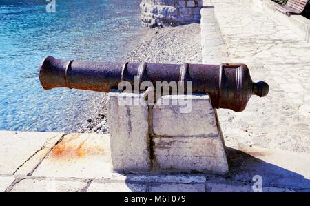 Vieilles et rouillées de la Marine austro-hongrois Cannon sur la pierre placée sur la côte de la mer croate dans Ika Banque D'Images