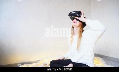 Belle et joyeuse femmes immergé dans la réalité virtuelle dans spec Banque D'Images