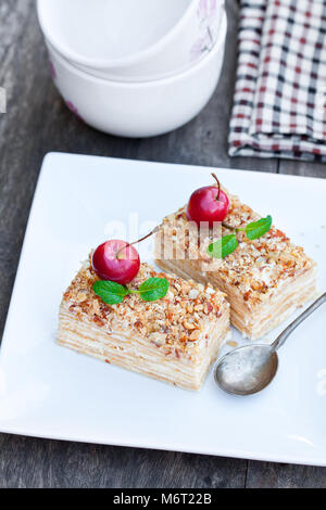 Napoléon gâteau avec les pommes sauvages et de menthe sur plaque carrée Banque D'Images