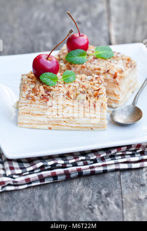 Napoléon gâteau avec les pommes sauvages et de menthe sur plaque carrée Banque D'Images