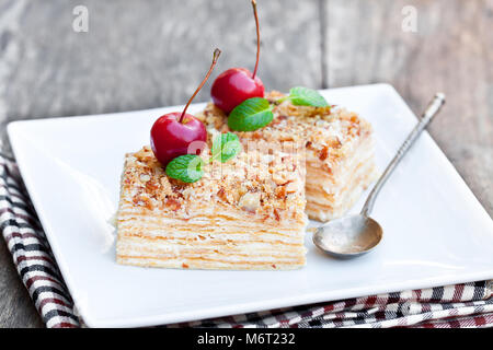 Napoléon gâteau avec les pommes sauvages et de menthe sur plaque carrée Banque D'Images