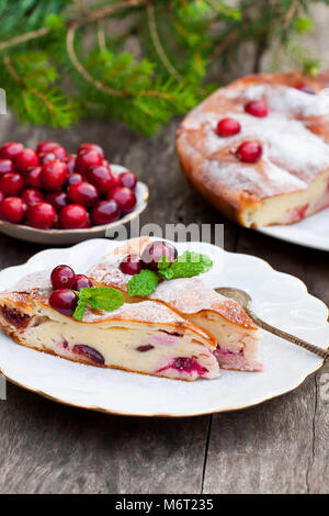 Tarte au fromage de canneberges et des branches d'arbre de Noël sur une table en bois Banque D'Images