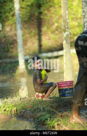 Enfance heureuse, de boue, jouer, Football, avoir du plaisir avec la nature, profiter de leur enfance, les enfants football,souvenirs, s'amusant, pour les enfants, cycle arbre avec boy, game Banque D'Images