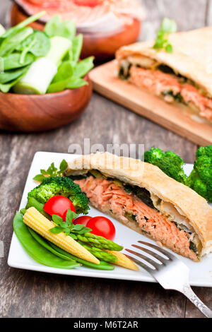 Filet de saumon sur les poireaux et spinachbaked en feuilleté aux légumes Banque D'Images