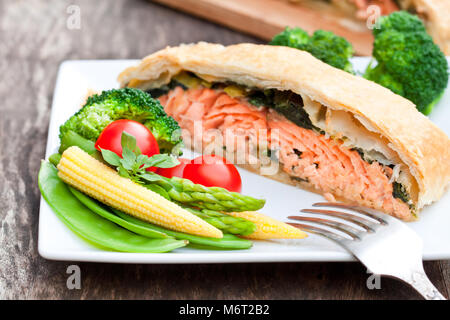 Filet de saumon sur les poireaux et spinachbaked en feuilleté aux légumes Banque D'Images