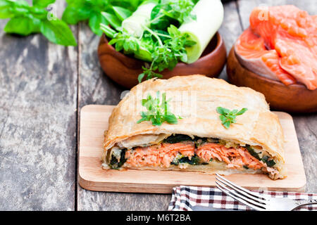 Filet de saumon sur les poireaux et spinachbaked en feuilleté aux légumes Banque D'Images