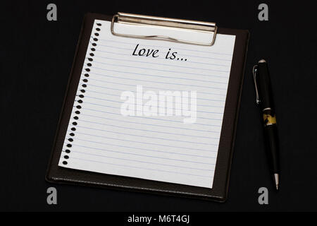 Vue de dessus du presse-papiers et feuille blanche avec écrit Lve est sur fond noir. Banque D'Images