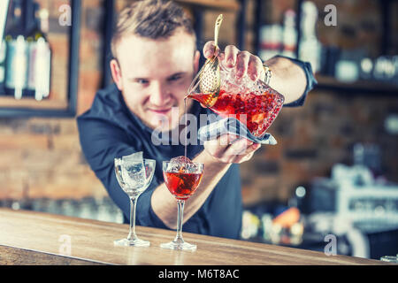 Bartender pouring cocktail boisson alcoolisée de Manhattan. Barman dans un pub ou un restaurant préparant un verre à cocktail. Banque D'Images