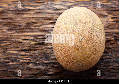 Un melon entier sur une vieille table en bois Banque D'Images