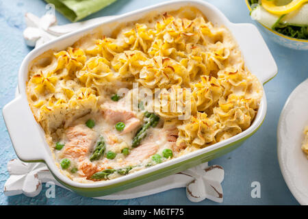 Cocotte au saumon, pommes de terre, asperges, petits pois et sauce crémeuse Banque D'Images