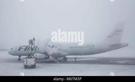 Un jet de Finnair sont les ailes de dégivrage à l'aéroport d'Ivalo , Inari, Finlande Banque D'Images