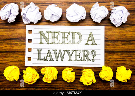 Texte manuscrit montrant Besoin d'un avocat. Concept d'affaires pour aider la justice plaidoyer écrit sur collant, collant, beaucoup de bois avec du papier plié et blanc Banque D'Images