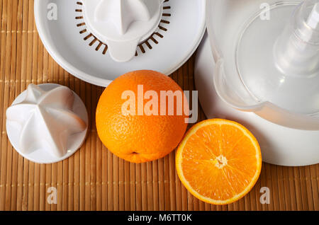 Presse-agrumes et fruits oranges sur mat Banque D'Images