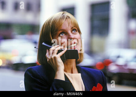 Historique 1996 CAUCASIAN BUSINESS WOMAN OUTDOORS WITH TÉLÉPHONE CELLULAIRE MOBILE MOTOROLA CORP (©1995) Banque D'Images